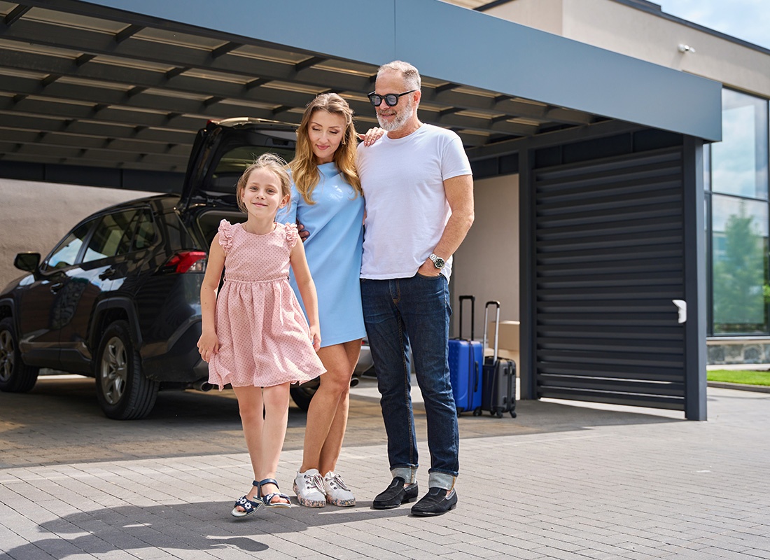Personal Insurance - Happy Family Standing in Front of Their Car and Home